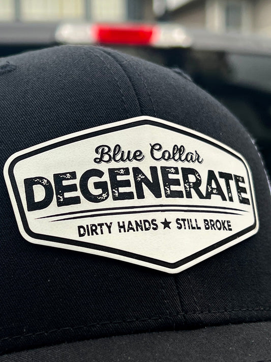 Close-up of the Blue Collar Degenerate patch reading Dirty Hands Still Broke on a black trucker hat.