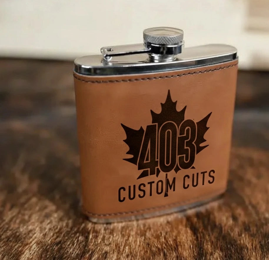 Walnut leatherette six-ounce flask with a black engraved 403 Custom Cuts logo.