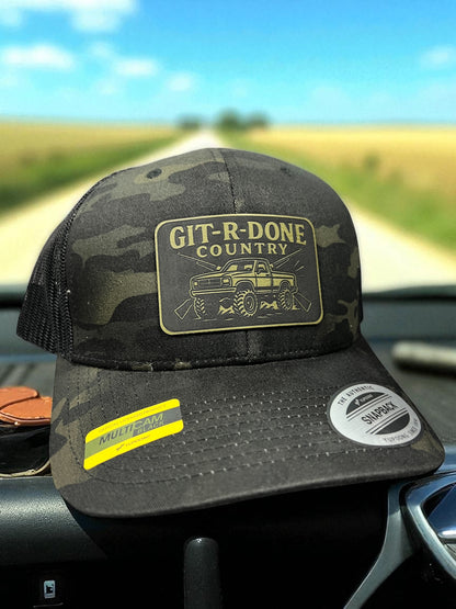 Git R Done trucker hat with laser-engraved leatherette patch, adjustable snapback, breathable mesh back, rugged country style for mud, backroads, and hard work