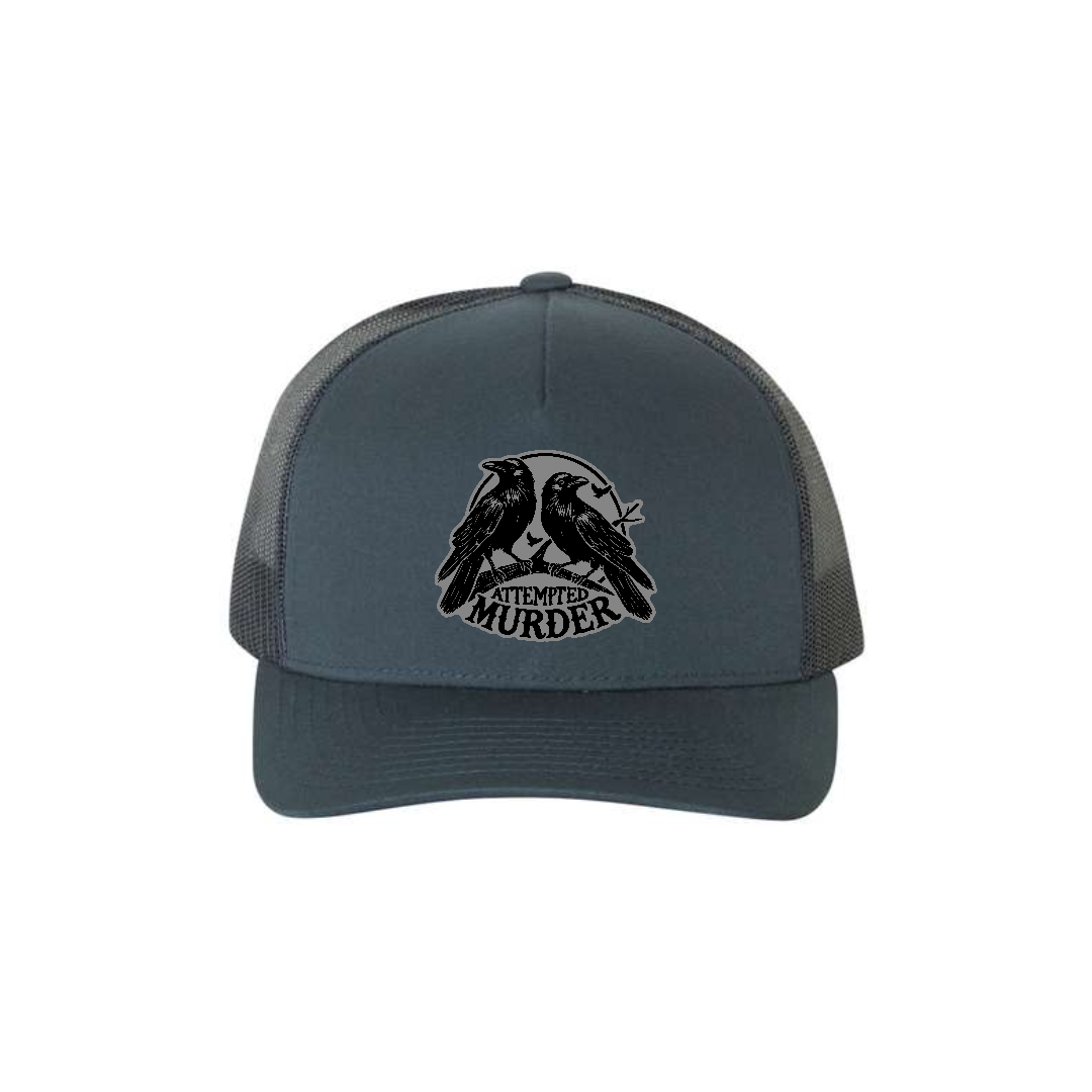 Attempted Murder 5-panel trucker hat in navy, front product mockup showing a grey crow design patch.