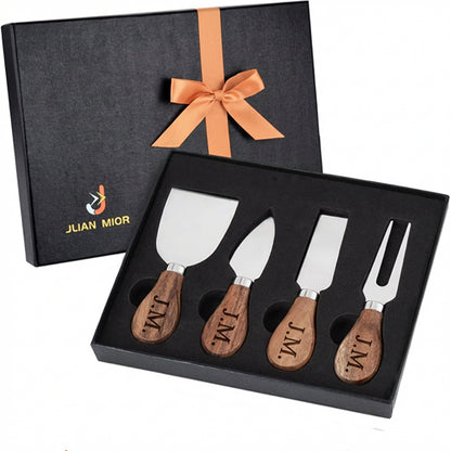 Four-piece cheese knife set with engraved wooden handles in a black gift box tied with an orange ribbon.