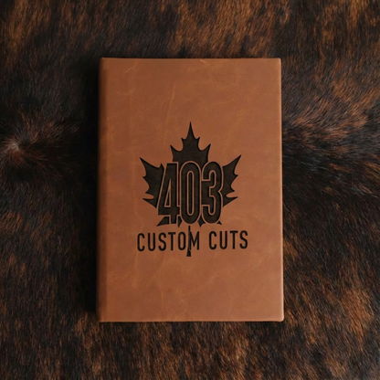 Rawhide leatherette journal with the engraved 403 Custom Cuts maple leaf logo on the cover.