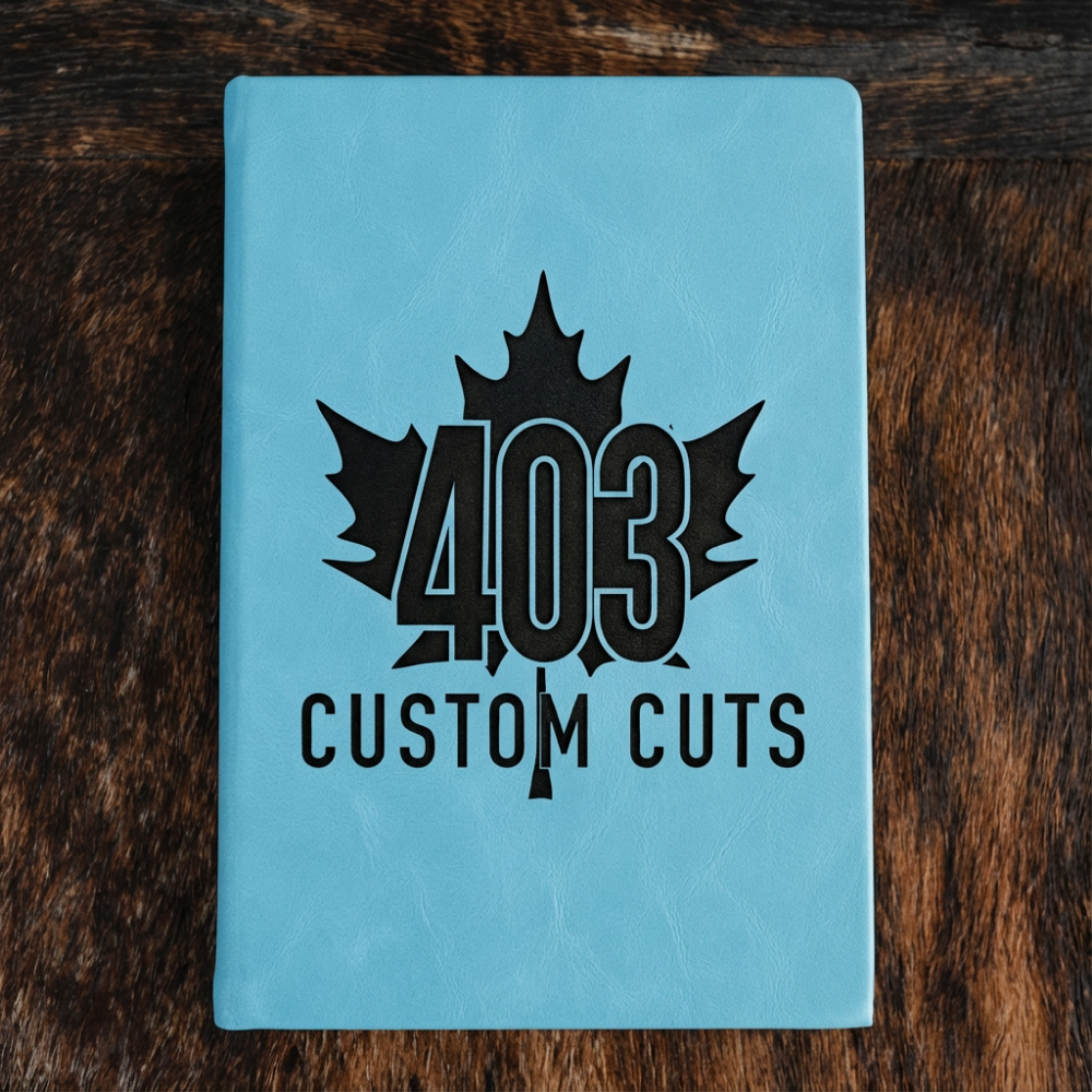 Sky Blue leatherette journal with the engraved 403 Custom Cuts maple leaf logo on the cover.