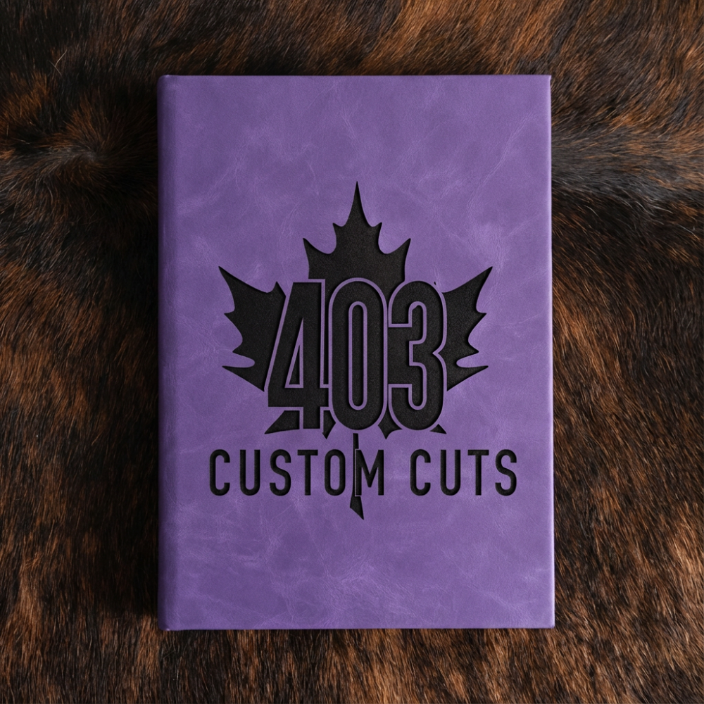 Violet leatherette journal with the engraved 403 Custom Cuts maple leaf logo on the cover.