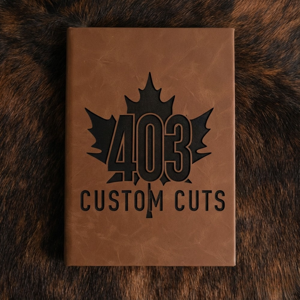 Walnut leatherette journal with the engraved 403 Custom Cuts maple leaf logo on the cover.