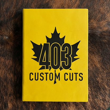 Yellow leatherette journal with the engraved 403 Custom Cuts maple leaf logo on the cover.