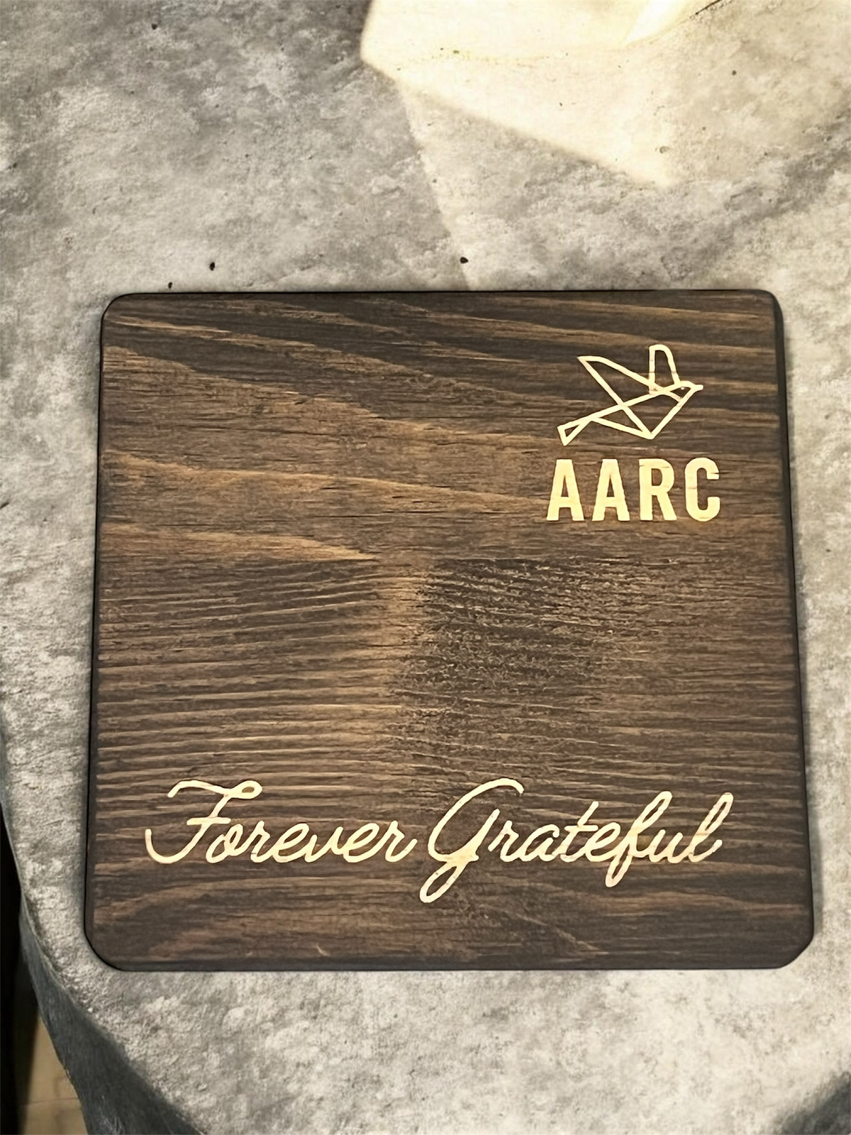 Square wooden coaster engraved with an AARC logo and Forever Grateful lettering.
