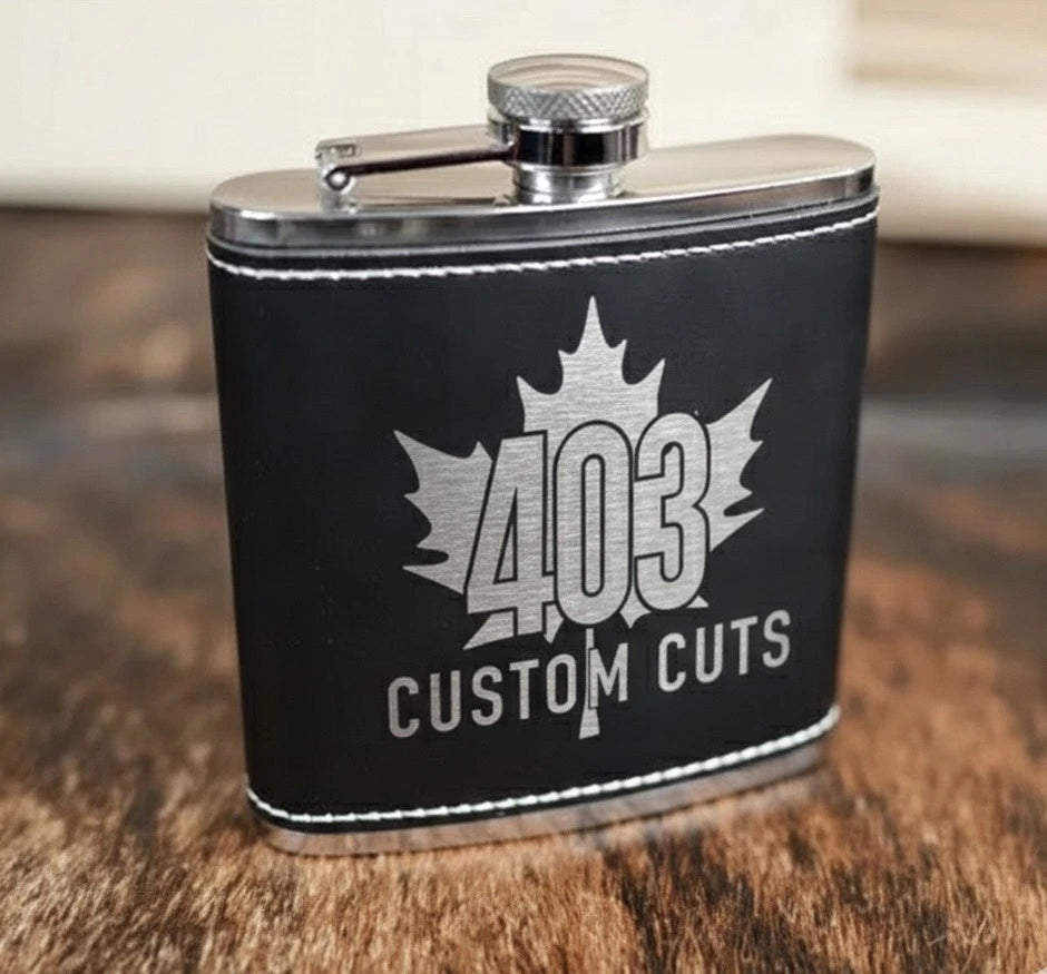 Black leatherette six-ounce flask with a silver engraved 403 Custom Cuts logo.