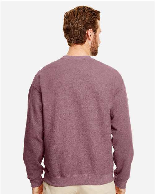 Model wearing a Gildan 18000 Heavy Blend crewneck sweatshirt in Heather Dark Maroon, back view.