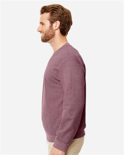 Model wearing a Gildan 18000 Heavy Blend crewneck sweatshirt in Heather Dark Maroon, side view.