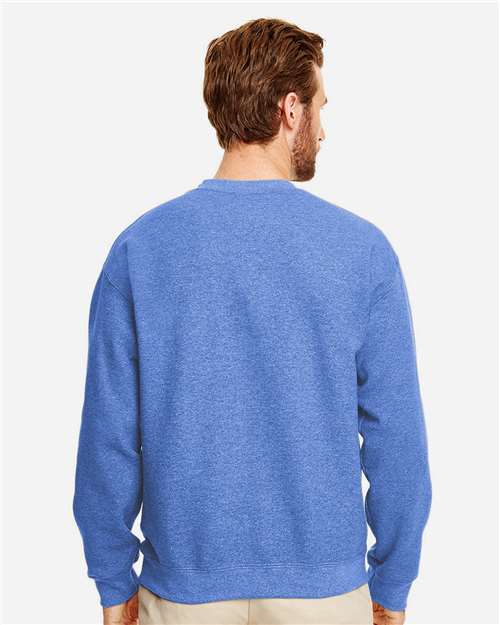 Model wearing a Gildan 18000 Heavy Blend crewneck sweatshirt in Heather Deep Royal, back view.