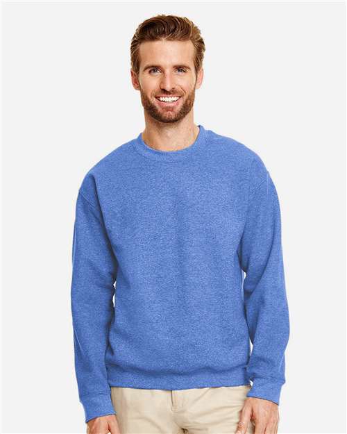 Model wearing a Gildan 18000 Heavy Blend crewneck sweatshirt in Heather Deep Royal, front view.