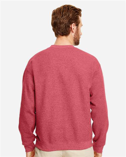 Model wearing a Gildan 18000 Heavy Blend crewneck sweatshirt in Heather Scarlet Red, back view.