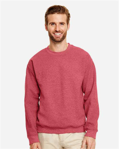 Model wearing a Gildan 18000 Heavy Blend crewneck sweatshirt in Heather Scarlet Red, front view.