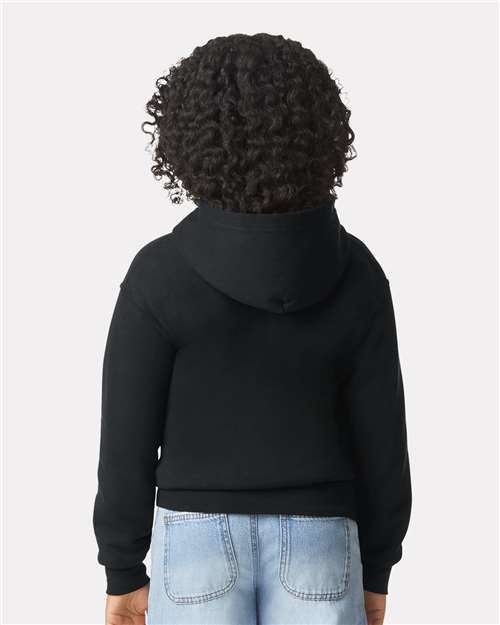 Model wearing a Gildan 18600B Heavy Blend youth full-zip hoodie in Black, back view.