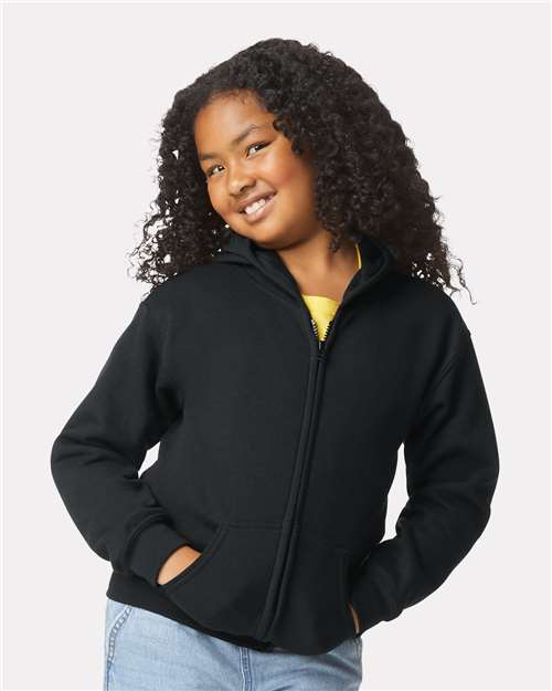 Model wearing a Gildan 18600B Heavy Blend youth full-zip hoodie in Black, front view.