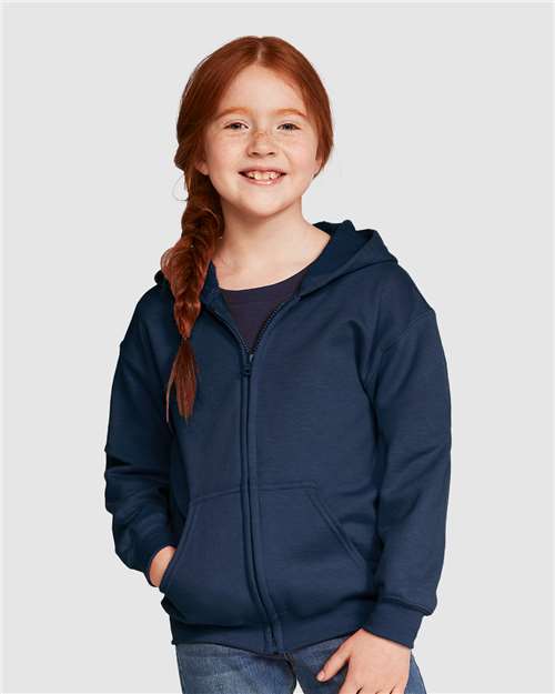 Model wearing a Gildan 18600B Heavy Blend youth full-zip hoodie in Navy, front view.
