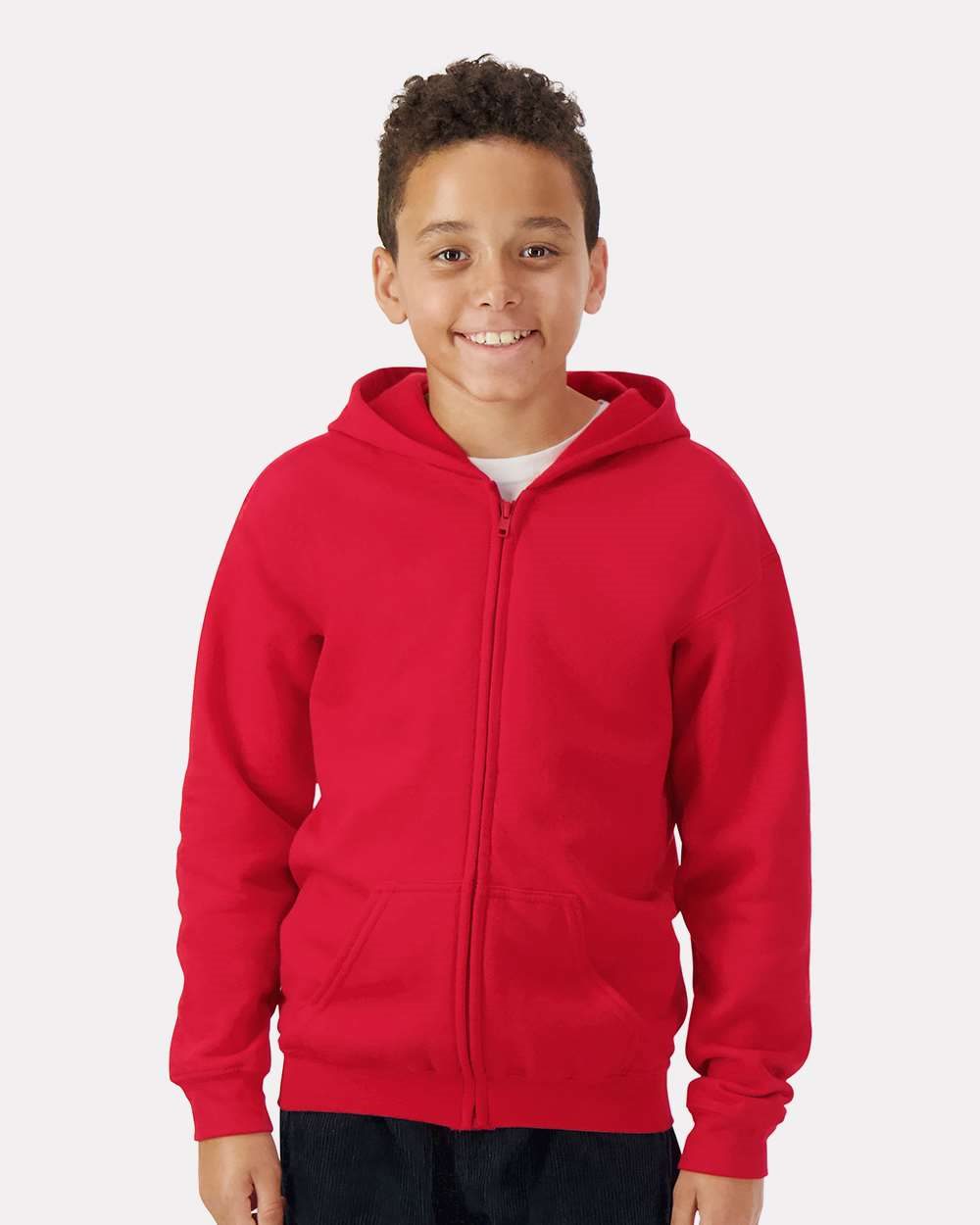 Model wearing a Gildan 18600B Heavy Blend youth full-zip hoodie in Red, front lifestyle view.
