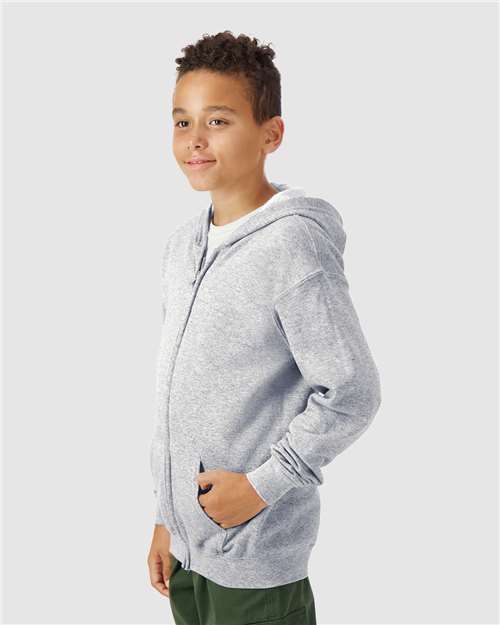 Model wearing a Gildan 18600B Heavy Blend youth full-zip hoodie in Sport Grey, side view.