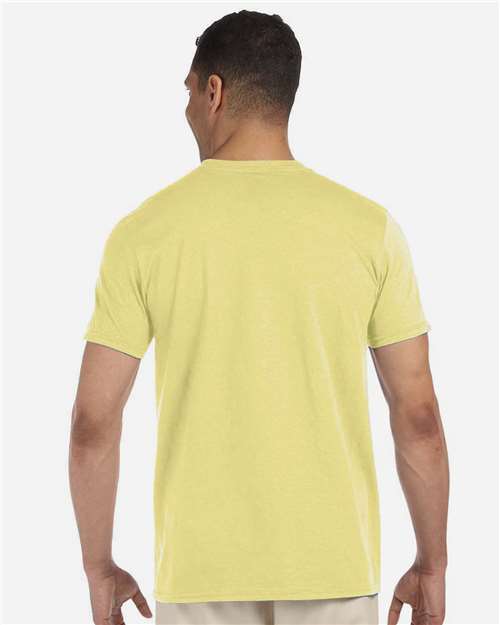 Model wearing a Gildan 64000 Softstyle T-shirt in Cornsilk, back view.