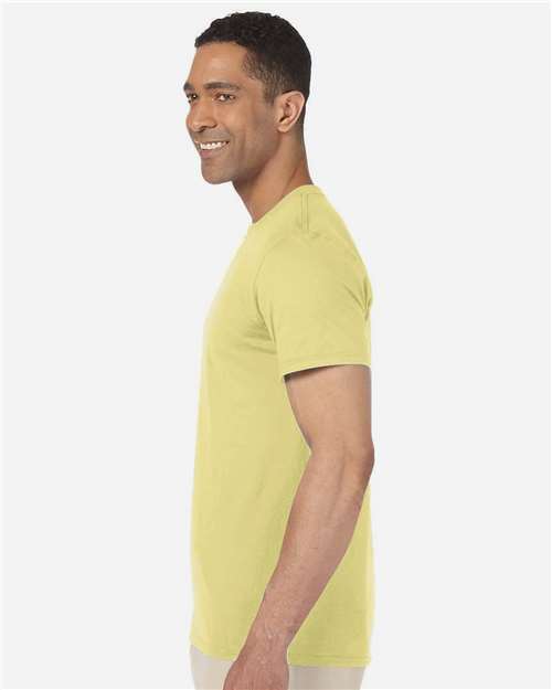 Model wearing a Gildan 64000 Softstyle T-shirt in Cornsilk, side view.