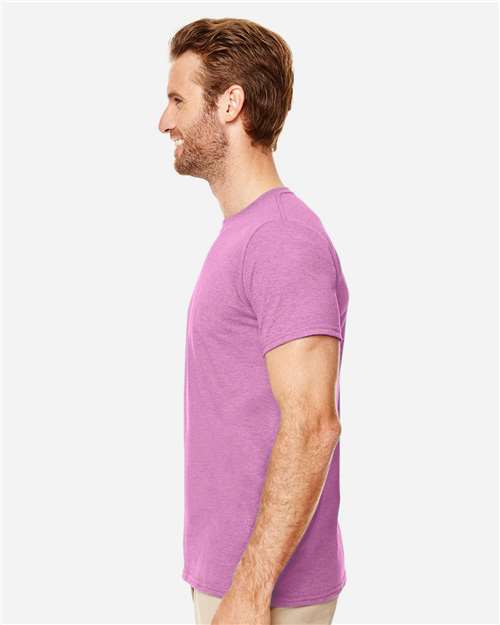 Model wearing a Gildan 64000 Softstyle T-shirt in Heather Radiant Orchid, side view.
