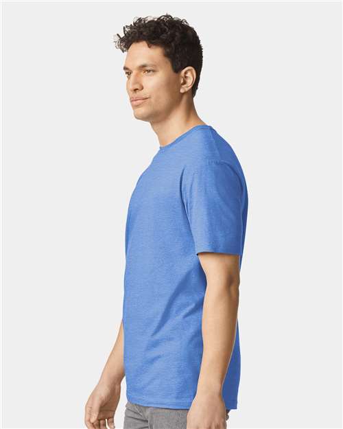 Model wearing a Gildan 64000 Softstyle T-shirt in Heather Royal, side view.