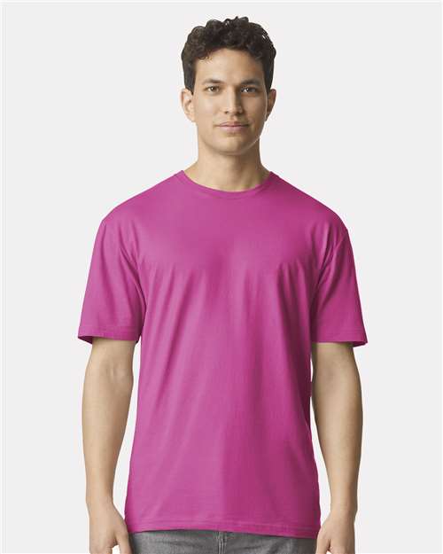 Model wearing a Gildan 64000 Softstyle T-shirt in Heliconia, front view.