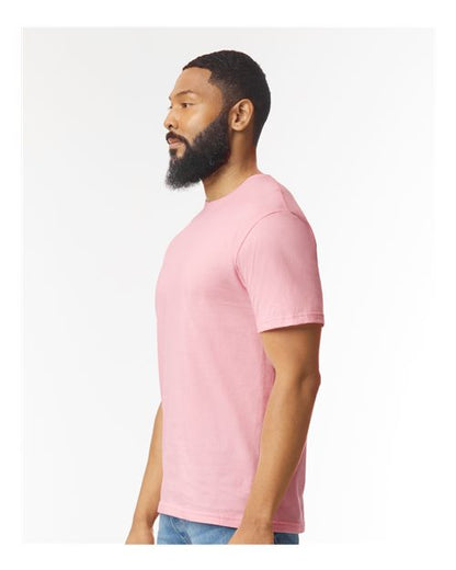 Model wearing a Gildan 64000 Softstyle T-shirt in Light Pink, side view.