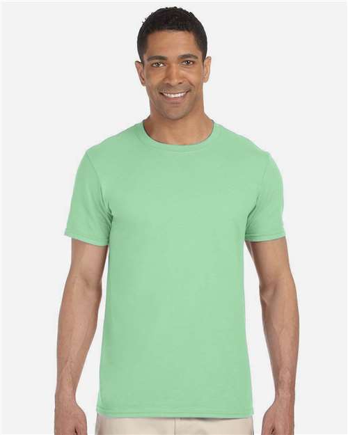 Model wearing a Gildan 64000 Softstyle T-shirt in Mint Green, front view.