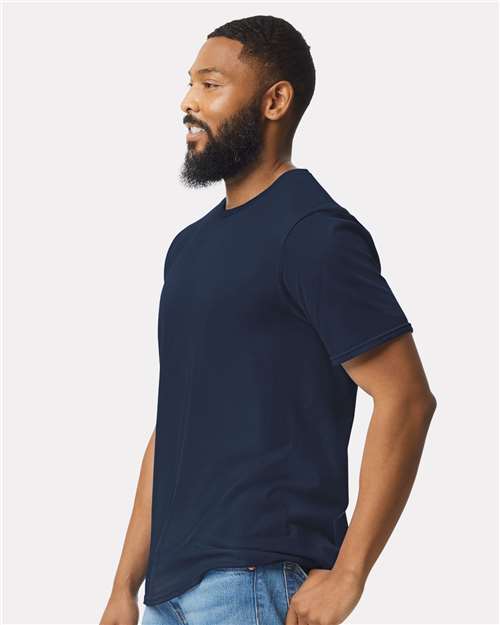 Model wearing a Gildan 64000 Softstyle T-shirt in Navy, side view.