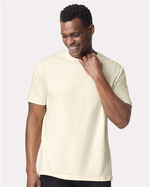 Model wearing a Gildan 64000 Softstyle T-shirt in Off White, front view.
