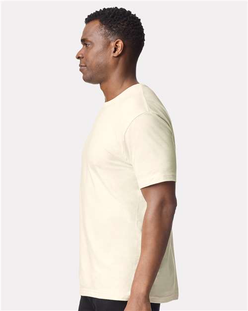 Model wearing a Gildan 64000 Softstyle T-shirt in Off White, side view.