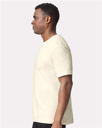 Model wearing a Gildan 64000 Softstyle T-shirt in Off White, side view.