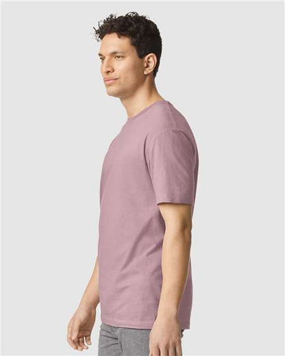 Model wearing a Gildan 64000 Softstyle T-shirt in Paragon, side view.