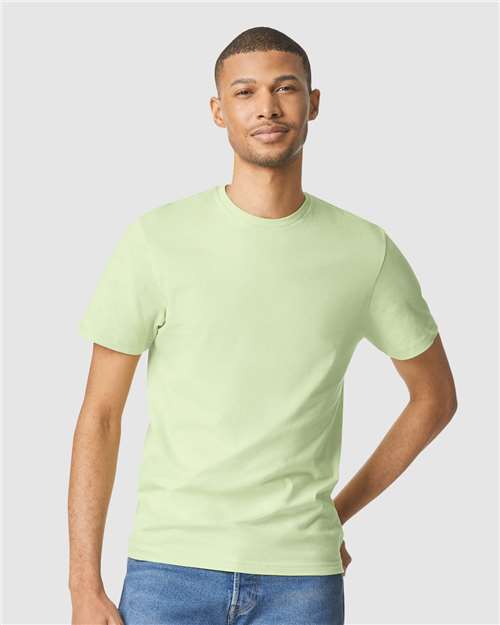 Model wearing a Gildan 64000 Softstyle T-shirt in Pistachio, front view.
