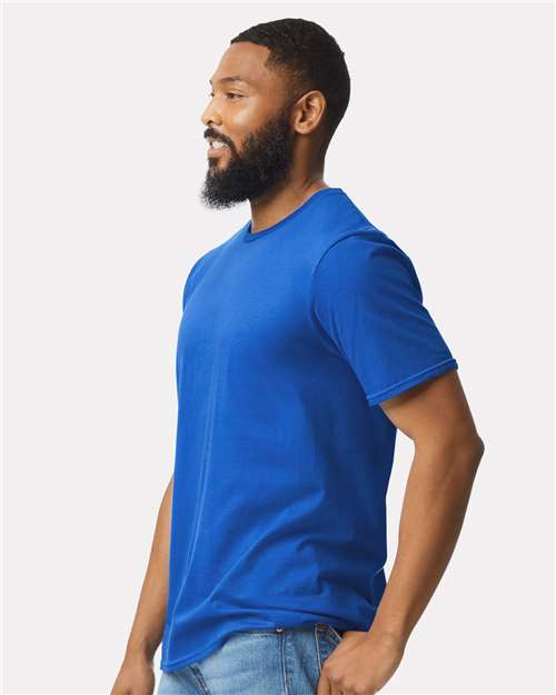 Model wearing a Gildan 64000 Softstyle T-shirt in Royal, side view.