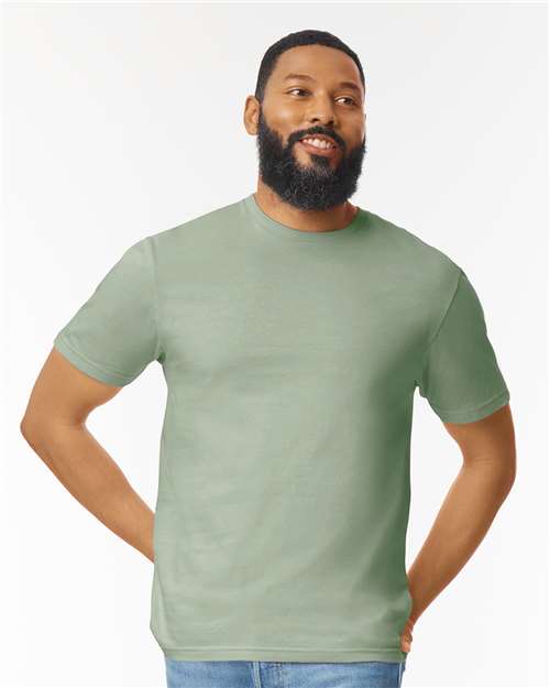 Model wearing a Gildan 64000 Softstyle T-shirt in Sage, front view.