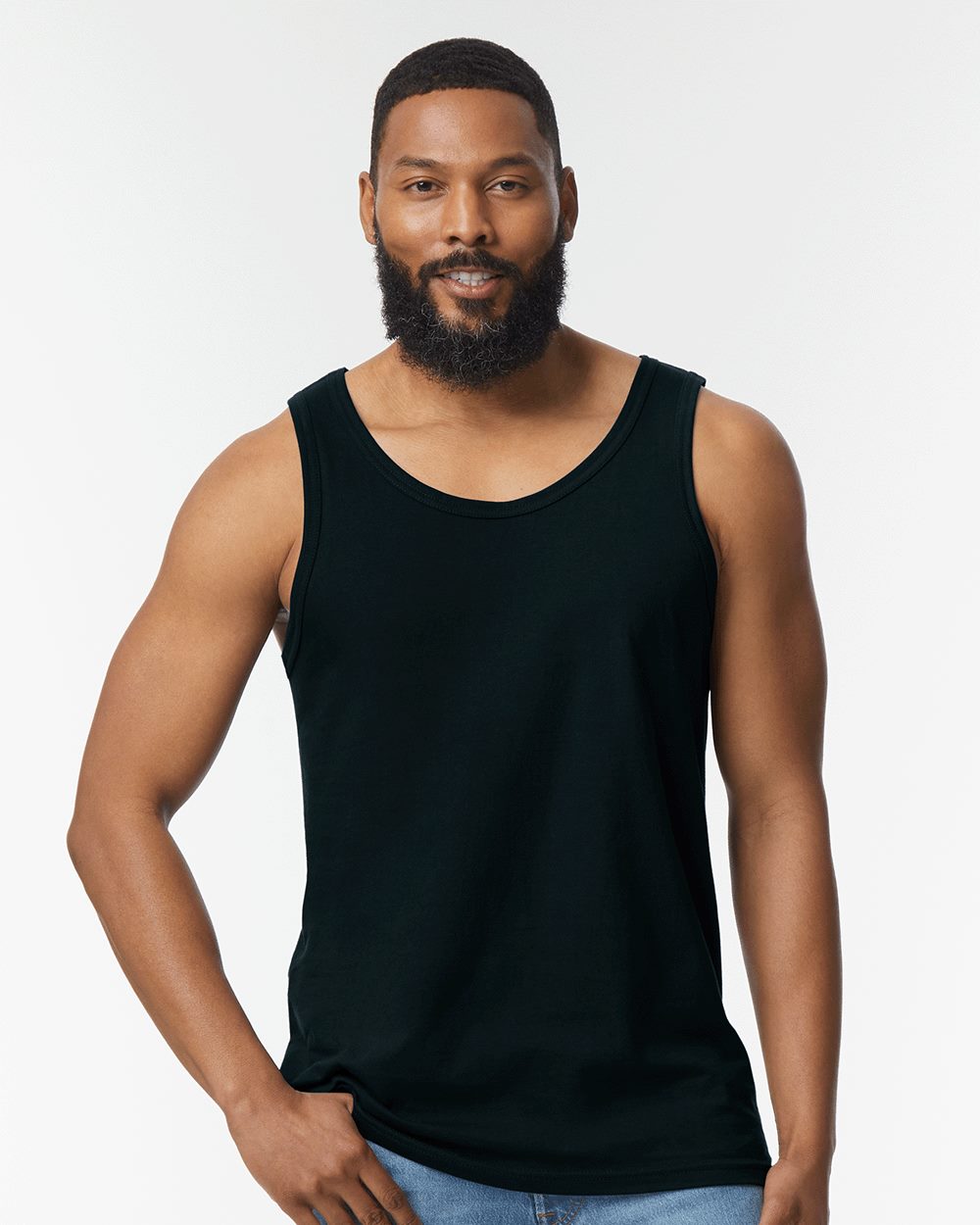 Model wearing a Gildan 64200 Softstyle men's tank top in Black, front lifestyle view.