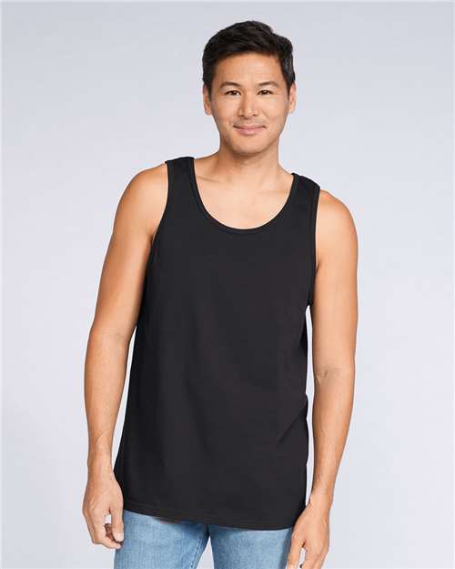 Model wearing a Gildan 64200 Softstyle men's tank top in Black, front view.