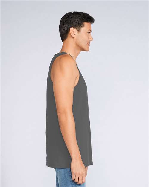 Model wearing a Gildan 64200 Softstyle men's tank top in Charcoal, side view.