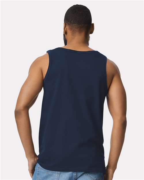 Model wearing a Gildan 64200 Softstyle men's tank top in Navy, back view.