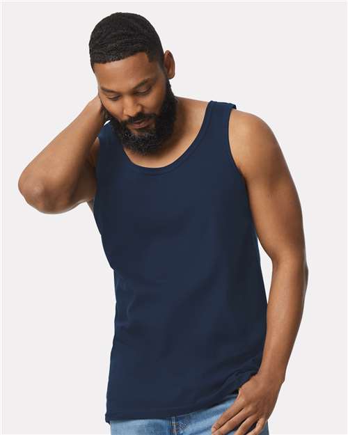 Model wearing a Gildan 64200 Softstyle men's tank top in Navy, front view.