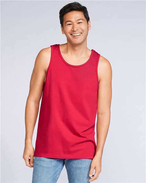 Model wearing a Gildan 64200 Softstyle men's tank top in Red, front view.
