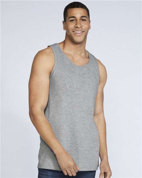 Model wearing a Gildan 64200 Softstyle men's tank top in Sport Grey, front view.