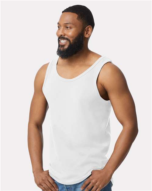 Model wearing a Gildan 64200 Softstyle men's tank top in White, side view.