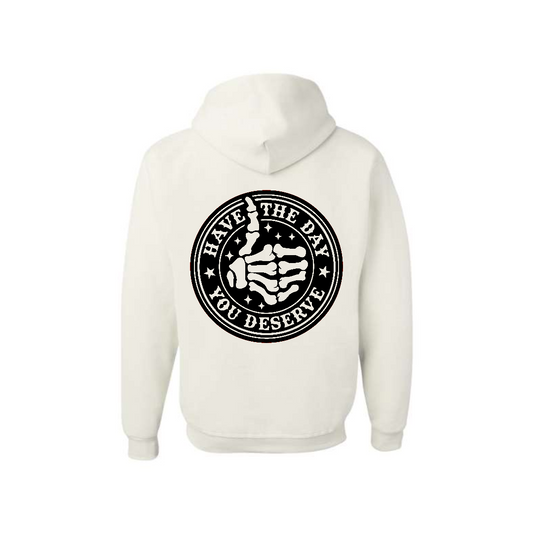 White Have the Day You Deserve graphic hoodie, back view showing the circular skeleton hand graphic.