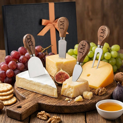 Personalized wooden handled cheese knives displayed with cheese and grapes beside a gift box.