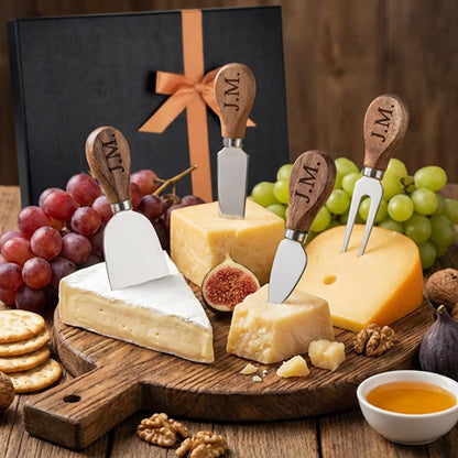 Personalized wooden handled cheese knives displayed with cheese and grapes beside a gift box.