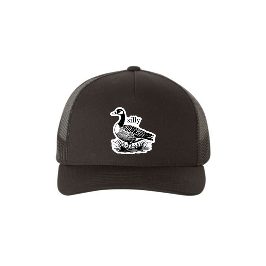 Silly Goose 5-panel trucker hat in black, front product mockup showing a white goose design patch.